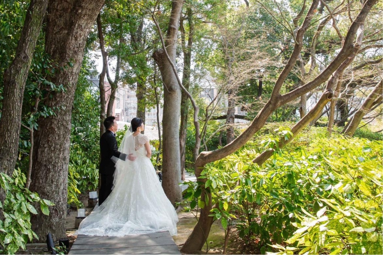 木々に囲まれた小道を歩く新郎新婦
