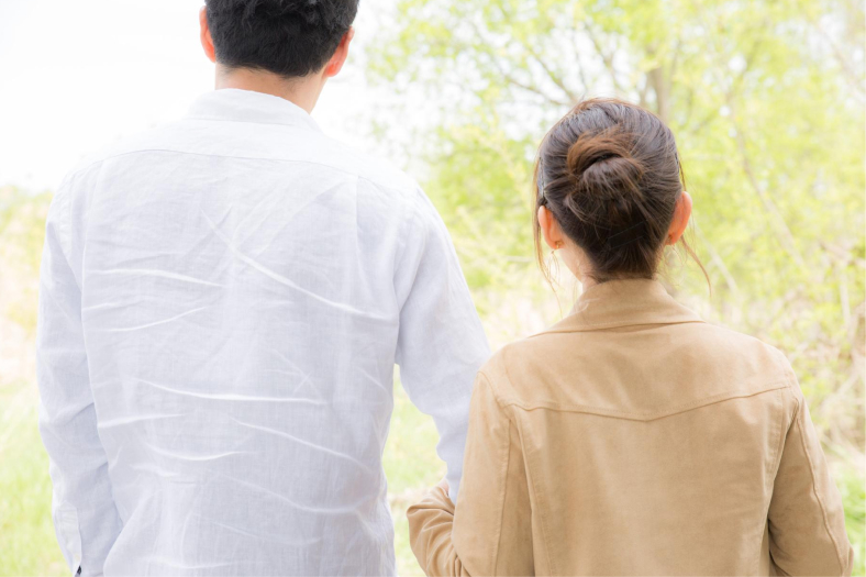 寄り添いながら歩く男女の後ろ姿